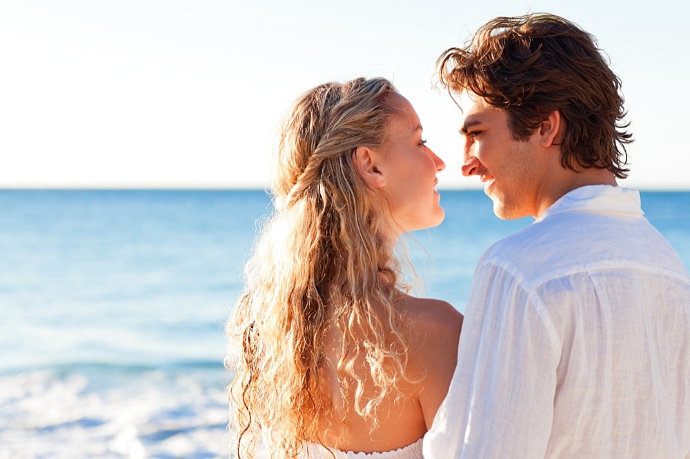 Back view of lovely couple on the beach