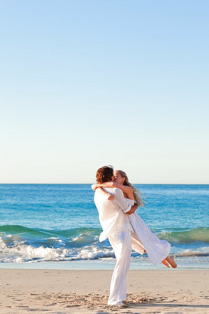 Man turning his girlfriend on the beach