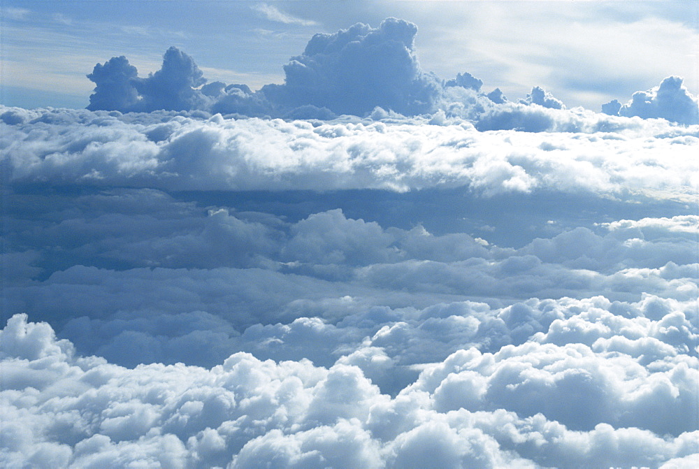 Aerial of banks of puffy white clouds seen from the air