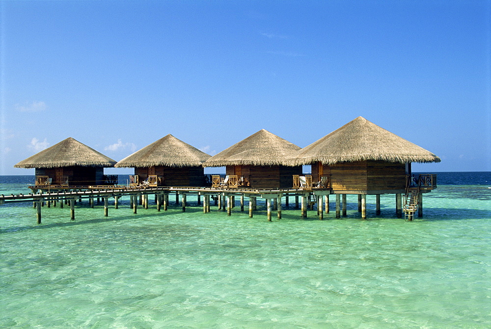 Thatched cabins above the ocean on the tropical island of Baros in the Maldive Islands, Indian Ocean, Asia