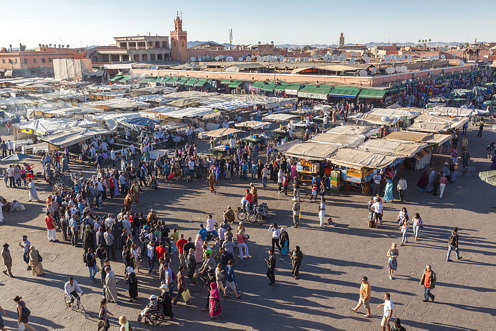 Passers-by gather round street performers in Jemaa El Fna at dusk, Marrakesh, Morocco, North Africa, Africa