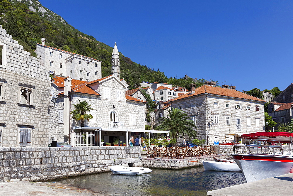 Perast harbour with cafes and boats moored up, Bay of Kotor, UNESCO World Heritage Site, Montenegro, Europe 