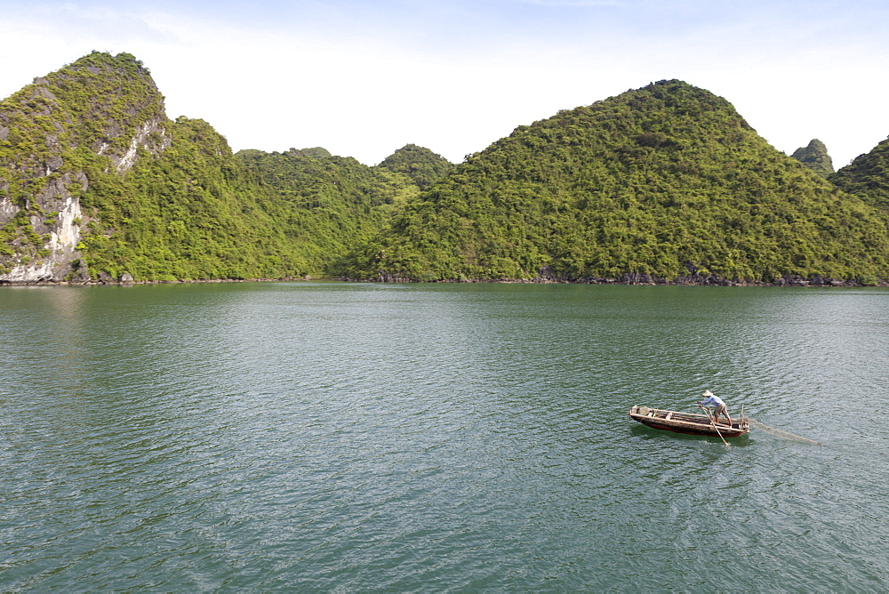 A man in a fishing boat, Ha Long Bay, UNESCO World Heritage Site, Vietnam, Indochina, Southeast Asia, Asia