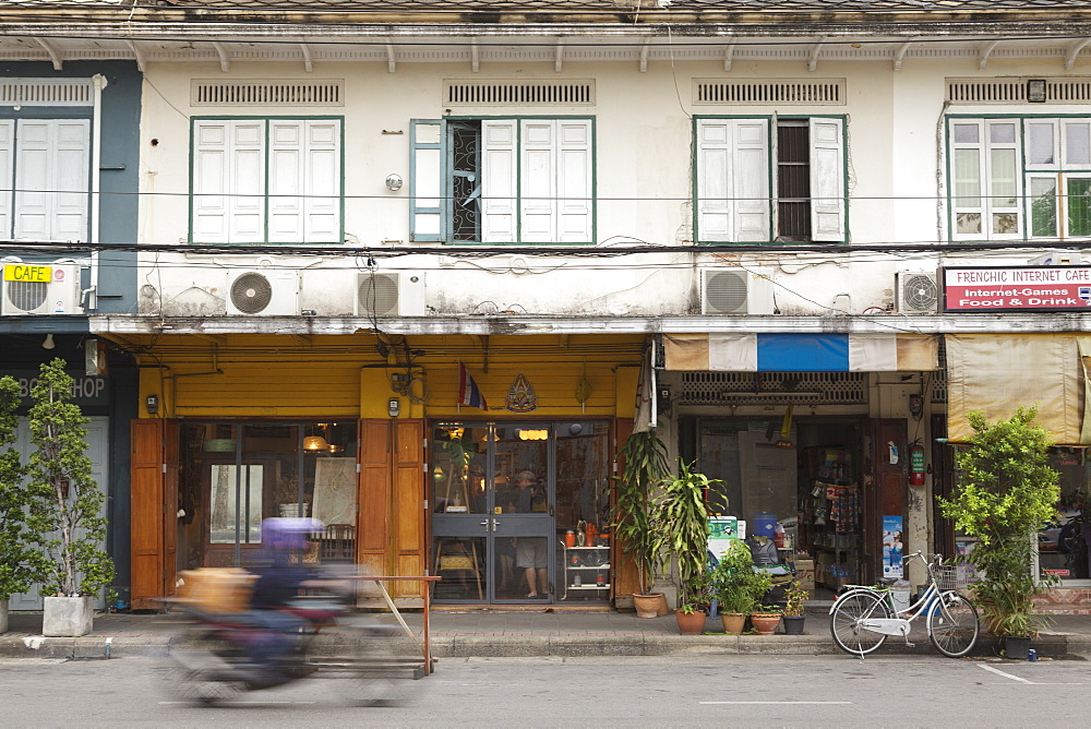 A motorbike rides past a shop front in Rattanakosin, Bangkok, Thailand, Southeast Asia, Asia