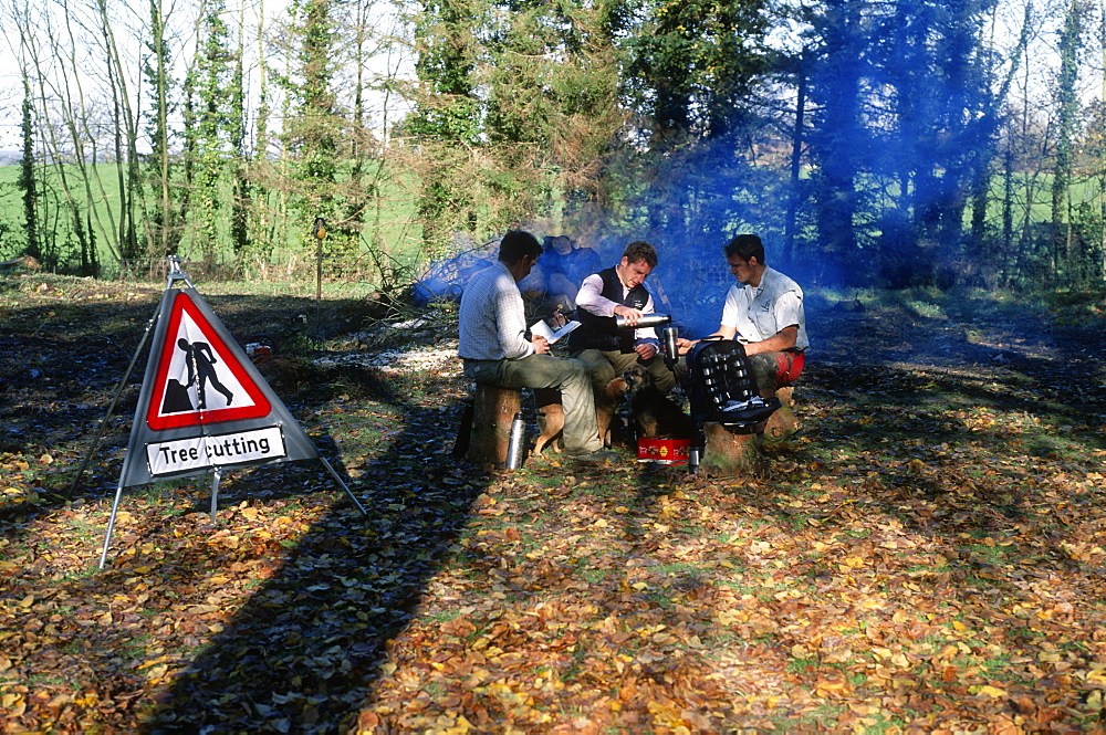 Tree surgeons resting by the fire, UK