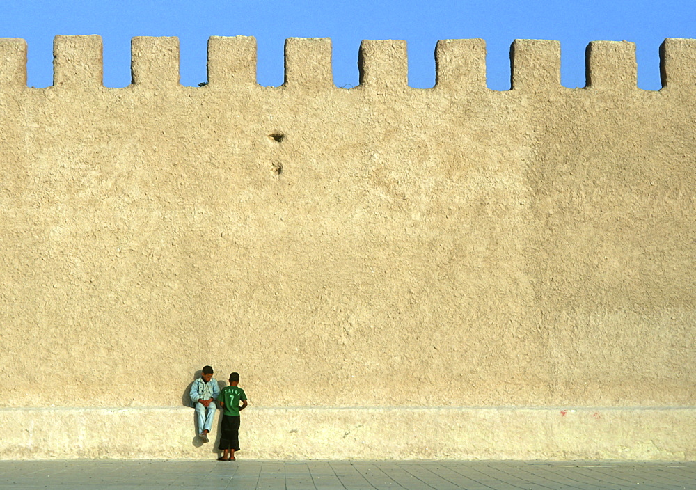 Young boys sitting on fort walls, Essaouira, Morocco