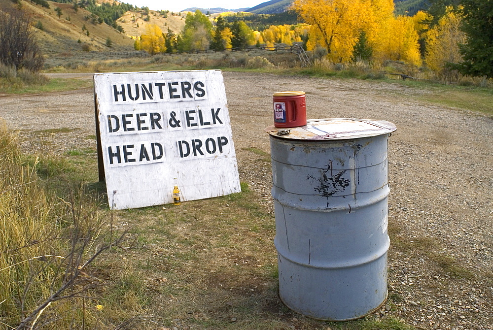 'Hunters Deer and Elk head drop' sign and barrel, Wyoming, USA. The Wyoming Game and Fish Department collect samples from deer and elk during the hunting season to test for Chronic Wasting Disease (CWD) in the state's deer and elk herds.  Chronic wasting disease is a fatal neurological disease that has been diagnosed in free ranging deer, elk and moose in 11 states and two Canadian provinces.