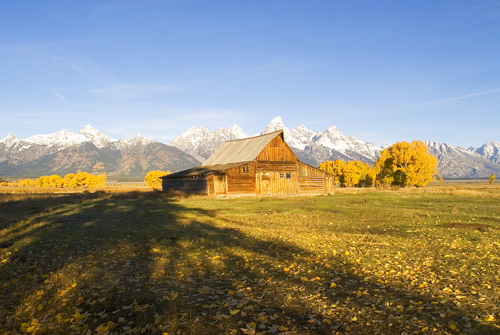 Traditional agricultural barn and the Teton Mountain range at dawn, Wyoming, USA