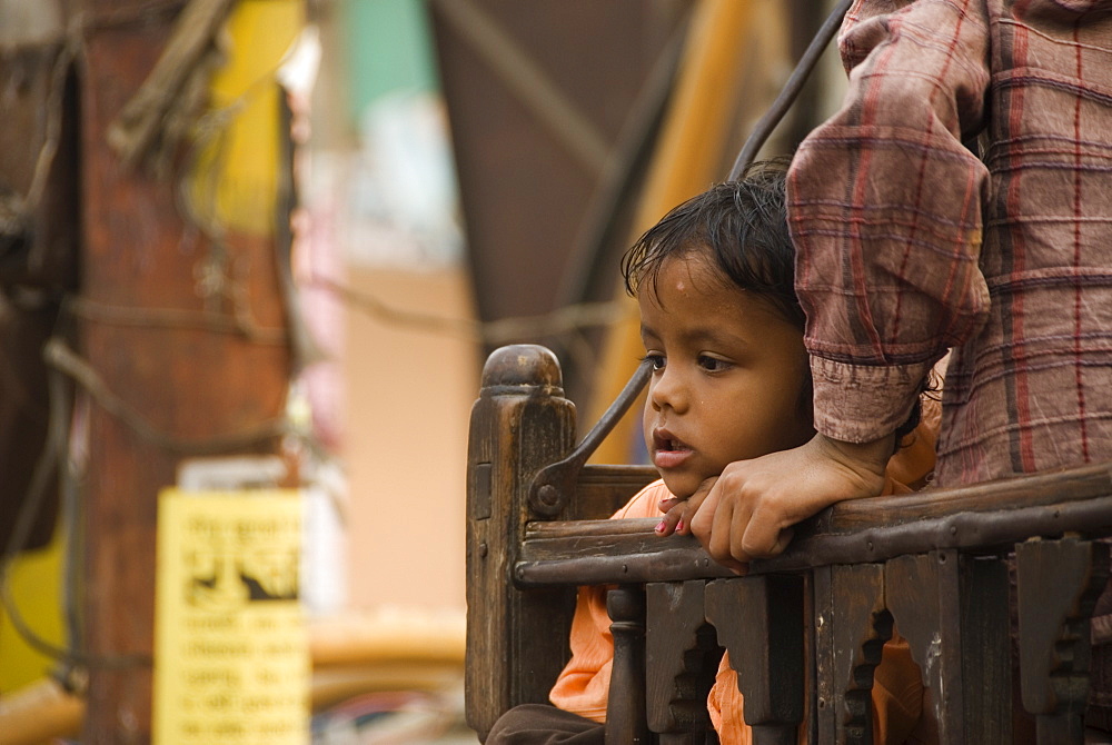 Young boy on wooden merry-go-round, Agra, Uttar Pradesh, India