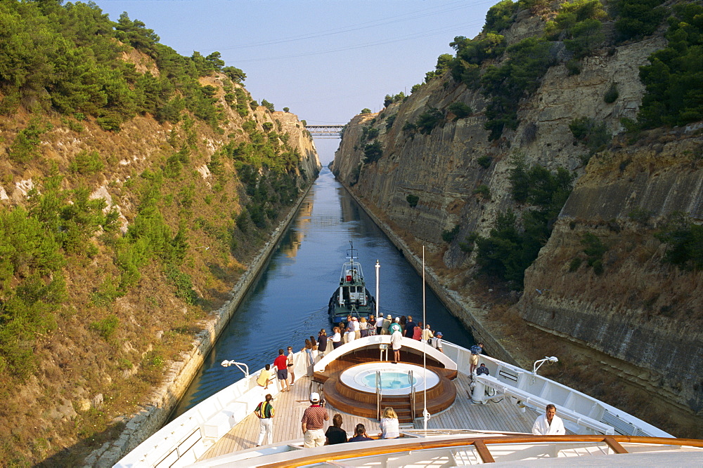 Tourists on the bow of a ship being pulled by tug through the Corinth Canal, Greece, Europe