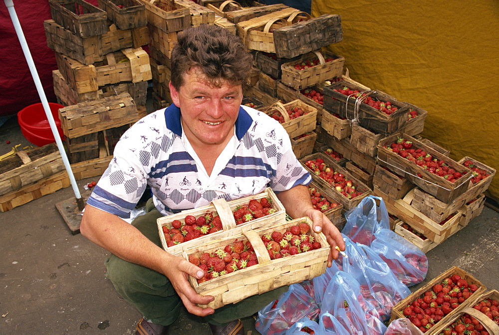 Portrait of a man with punnets of strawberries in the market at Malbork, Pomerania, Poland, Europe