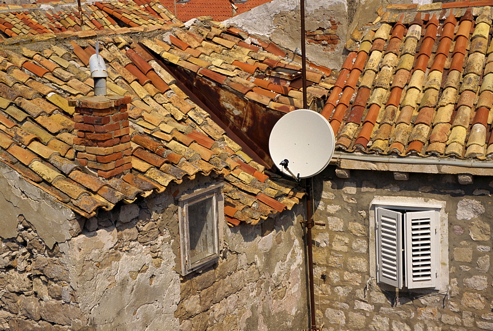 Close-up of roof tiles, old stone walls and satellite dish in the old town of Dubrovnik, Croatia, Europe