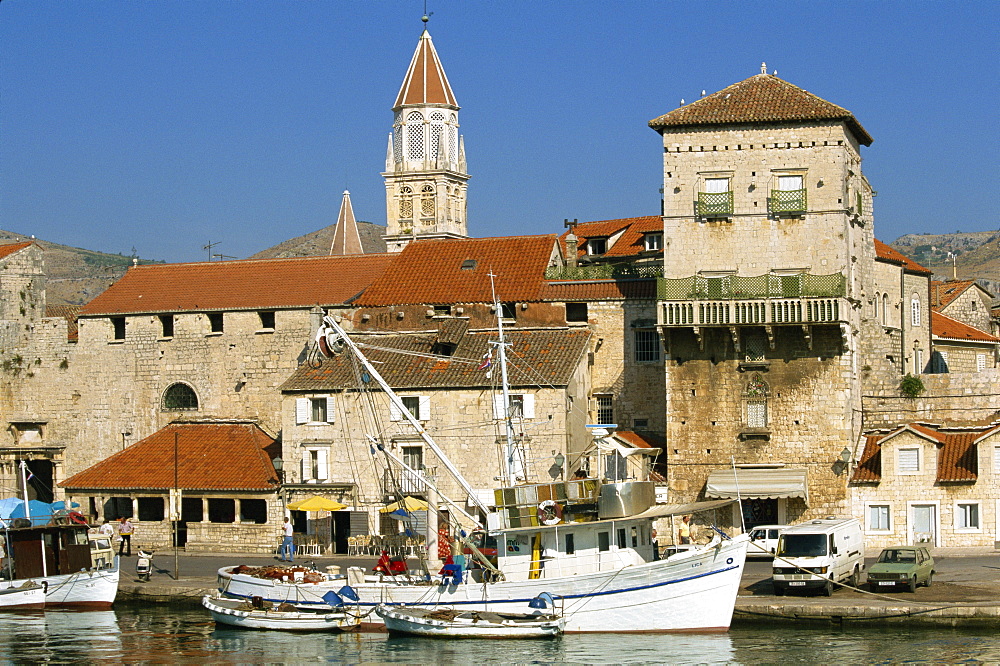 Fishing boats in harbour, with houses and tower beyond in the town of Trogir, Dalmatia, Croatia, Europe