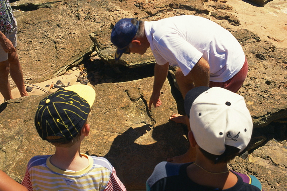 Examining dinosaur tracks, Broome, Kimberley, Western Australia, Australia, Pacific