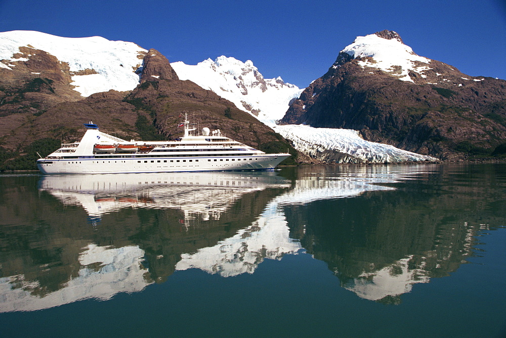 Reflections of the Seabourn Pride cruise ship, mountains and glacier in Chilean Fjordland, Magallanes, Chile, South America