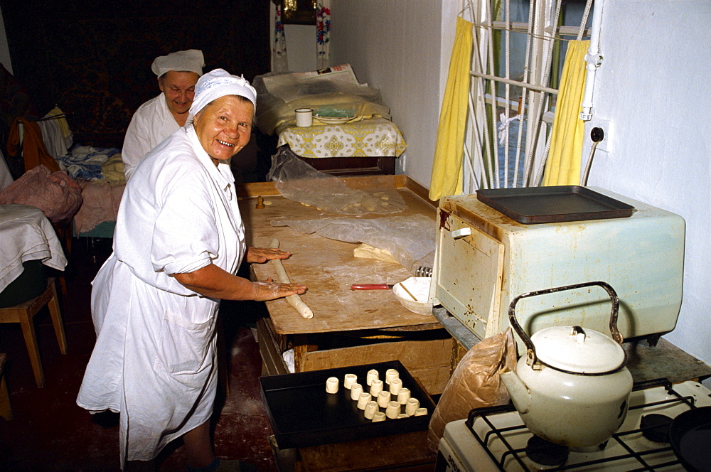 Women making scones in a small home oven in Yalta in the Ukraine, Europe