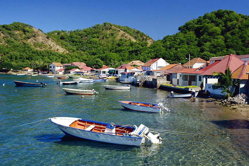 Boats moored behind houses built on the beach of a bay, Terre de Haut, Guadeloupe, Leeward Islands, West Indies, Caribbean, Central America