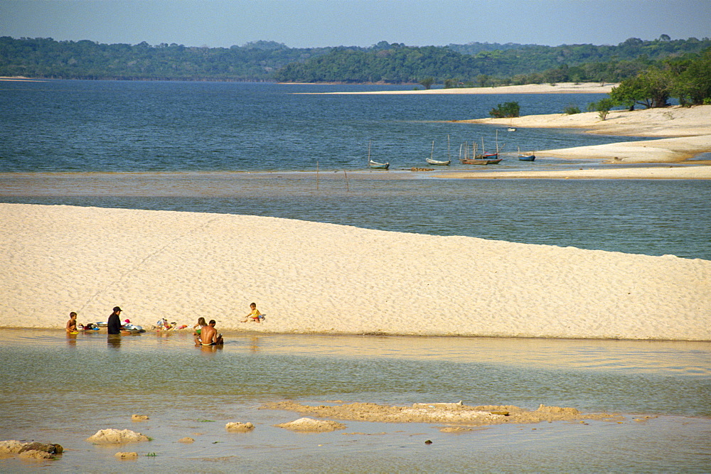 Groups of people and boats on the sand spit beaches at Alter do Chao on the Tapajos River in the Amazon area of Brazil, South America