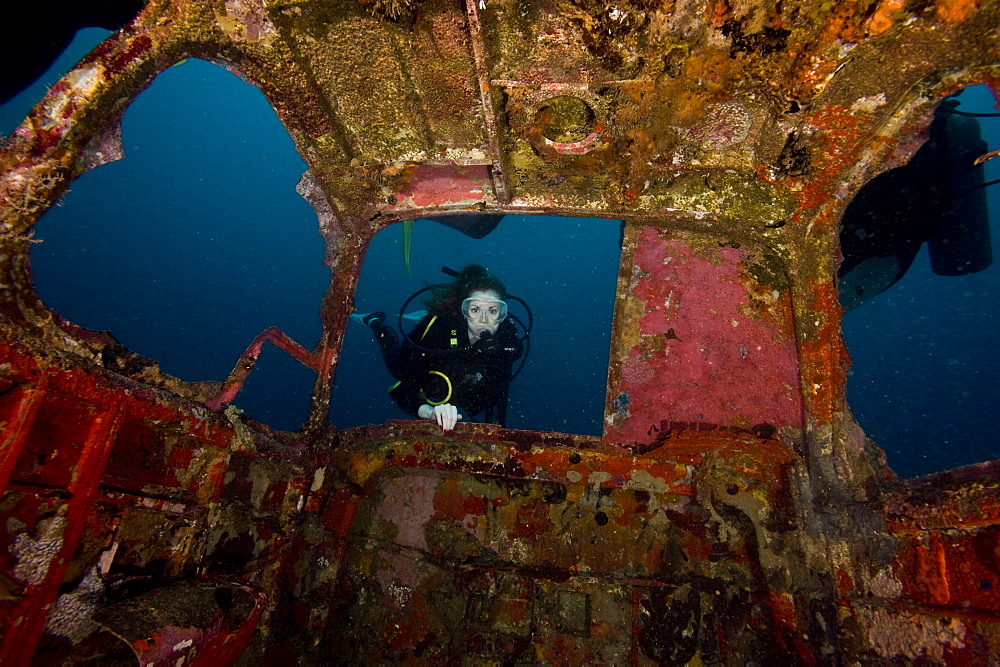 Diver entering the front window of a four seater plane wreck, Philippines, Southeast Asia, Asia