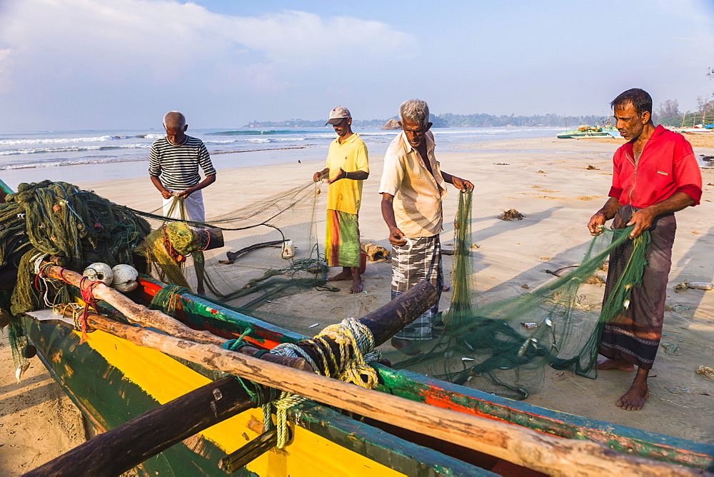 Fishermen sorting their catch on Weligama Beach, South Coast of Sri Lanka, Asia 