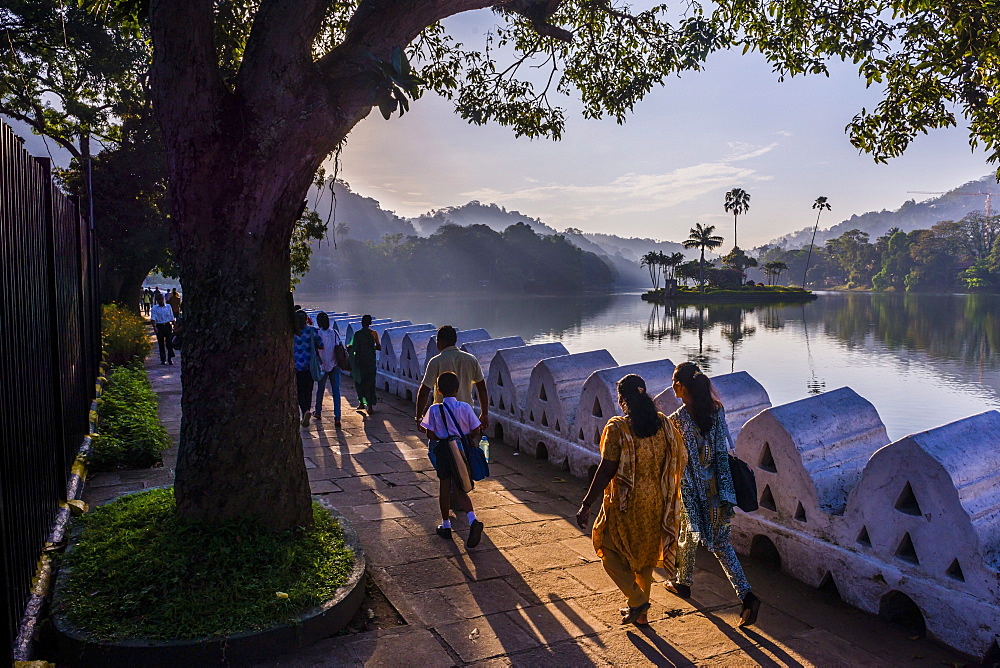 Sri Lankan people walking at Kandy Lake at sunrise, Kandy, Central Province, Sri Lanka, Asia 