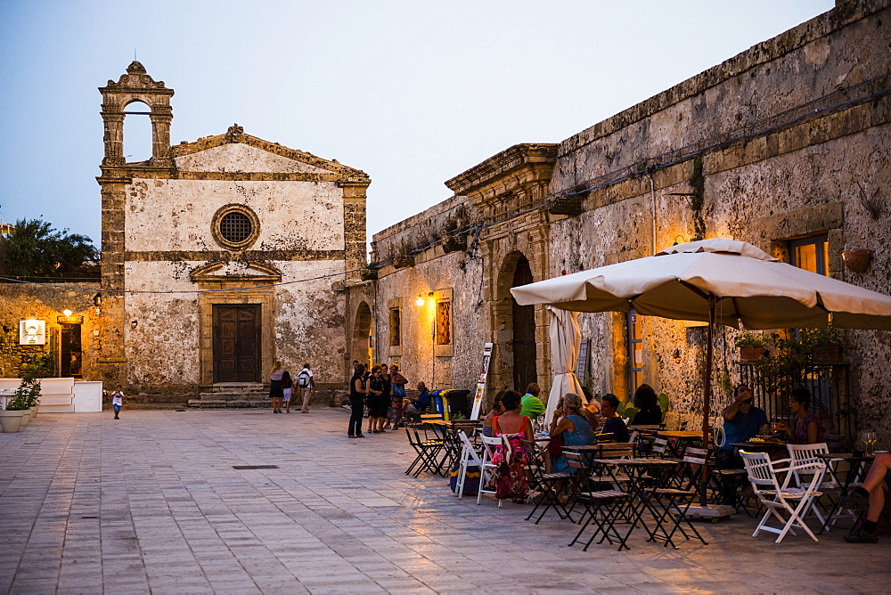 Tourist at a restaurant, Church of St Francis of Paolo in the main square, Marzamemi, Sicily, Italy, Europe 