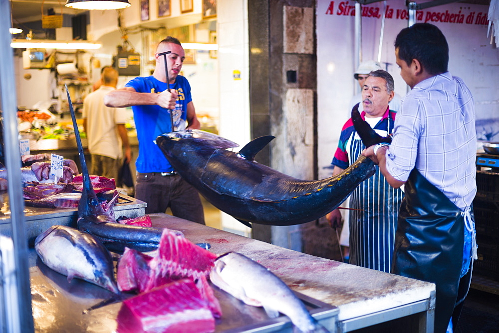 Fishmonger about to fillet an enormous tuna at Syracuse Market on Ortigia Island, Syracuse, Sicily, Italy, Europe