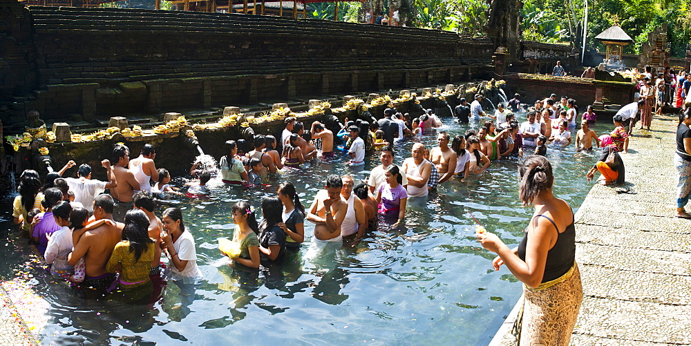 Panorama of Balinese people in Holy Spring Water in the Sacred Pool at Pura Tirta Empul Temple, Bali, Indonesia, Southeast Asia