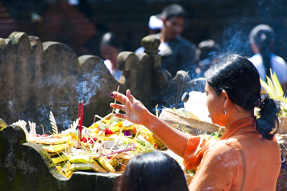 Balinese woman praying with incense at Pura Tirta Empul Hindu Temple, Bali, Indonesia, Southeast Asia, Asia