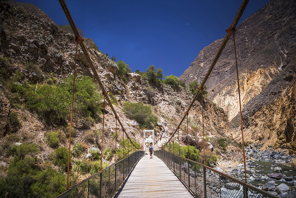 People trekking over Colca River Bridge, Colca Canyon, Peru, South America