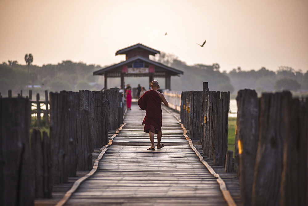 Buddhist Monk on U Bein Teak Bridge at sunrise, Mandalay, Mandalay Region, Myanmar (Burma), Asia