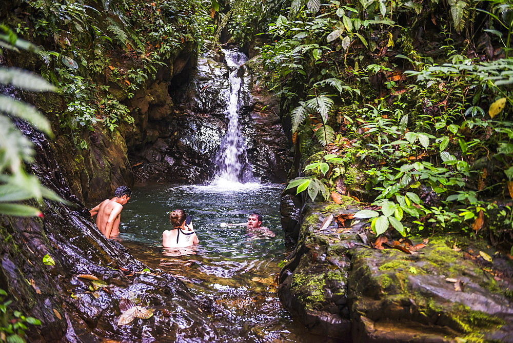 Tourists swimming under Cucharillos Waterfall, Choco Rainforest, Mashpi Cloud Forest, Pichincha Province, Ecuador, South America