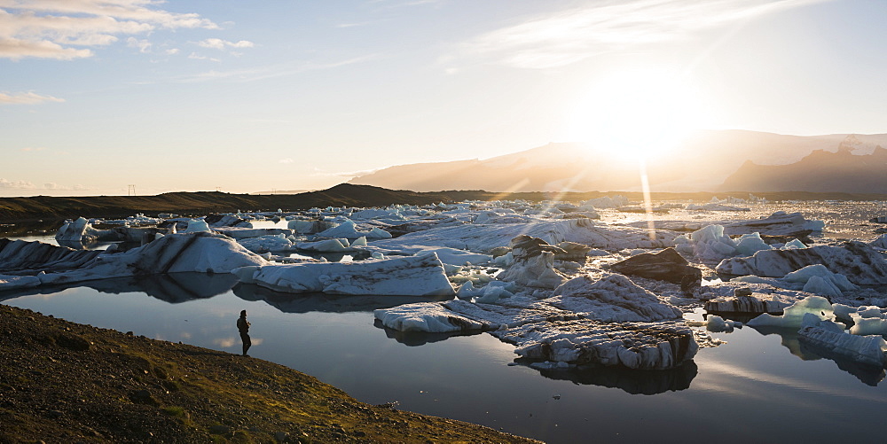 Tourist at Jokulsarlon Glacier Lagoon at sunset, South East Iceland, Iceland, Polar Regions