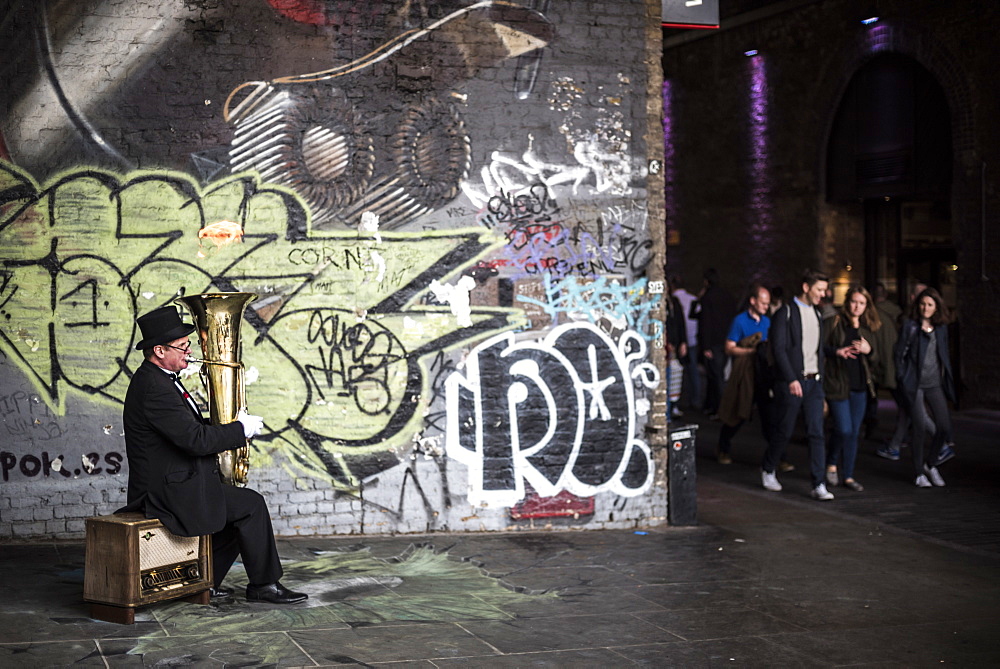 Street performer busking with a fire filled tuba on Clink Street, near Borough Market, Southwark, London, England, United Kingdom, Europe