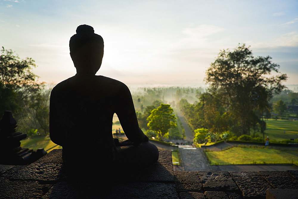 Stone Buddha silhouetted at sunrise at Borobudur Temple, UNESCO World Heritage Site, Java, Indonesia, Southeast Asia, Asia