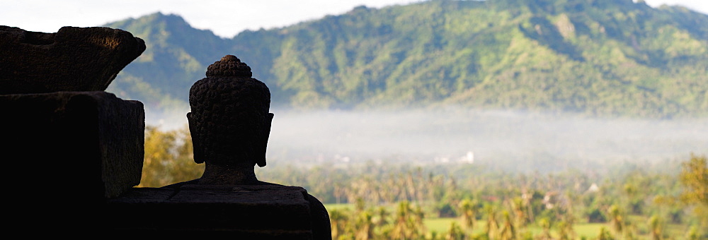 Silhouetted Buddha at Borobudur Temple at sunrise, UNESCO World Heritage Site, Java, Indonesia, Southeast Asia, Asia