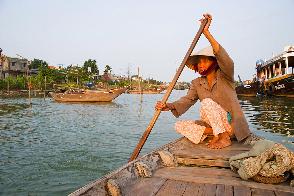 Old lady rowing in Hoi An Harbour, Vietnam, Indochina, Southeast Asia, Asia