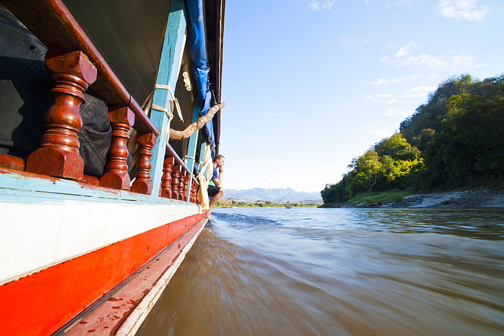 Tourist on the side of the slow boat from Thailand to Vientiane, Laos, Indochina, Southeast Asia, Asia