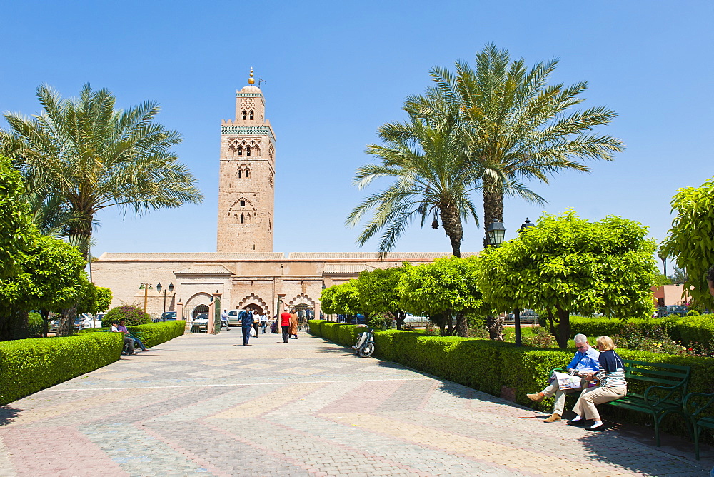 Tourists sitting in the gardens next to the Koutoubia Mosque, Marrakech (Marrakesh), Morocco, North Africa, Africa