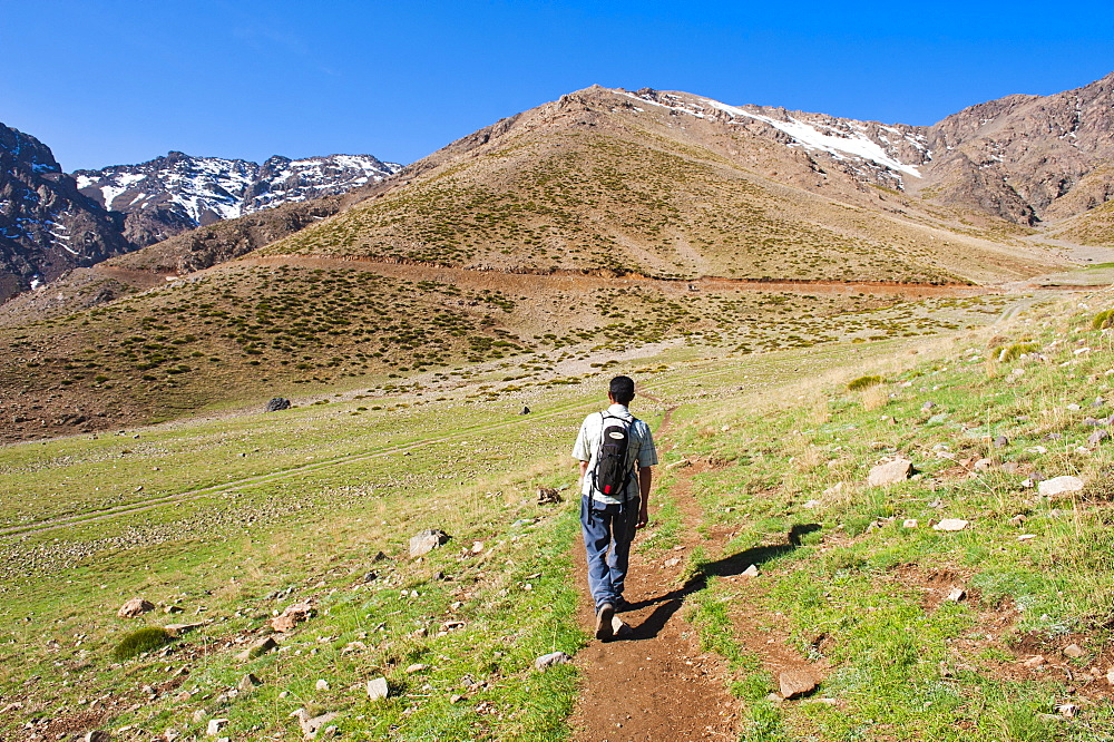 Trekking tour guide walking at Oukaimeden ski resort in summer, High Atlas Mountains, Morocco, North Africa, Africa 