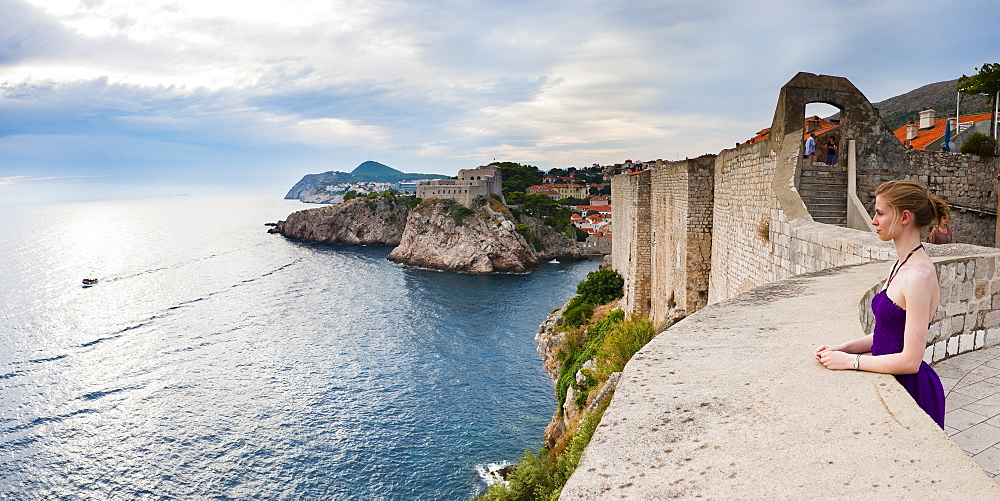 Tourist on Dubrovnik City Walls, with Fort Lovrijenac (St. Lawrence Fortress) in the background, Dubrovnik, Dalmatian Coast, Adriatic, Croatia, Europe 