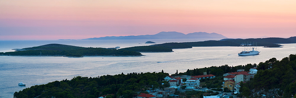 Pakleni Islands (Paklinski Islands) and Vis Island, a Mediterranean cruise ship moored at sunset, seen from Hvar Island, Dalmatian Coast, Adriatic Sea, Croatia, Europe 