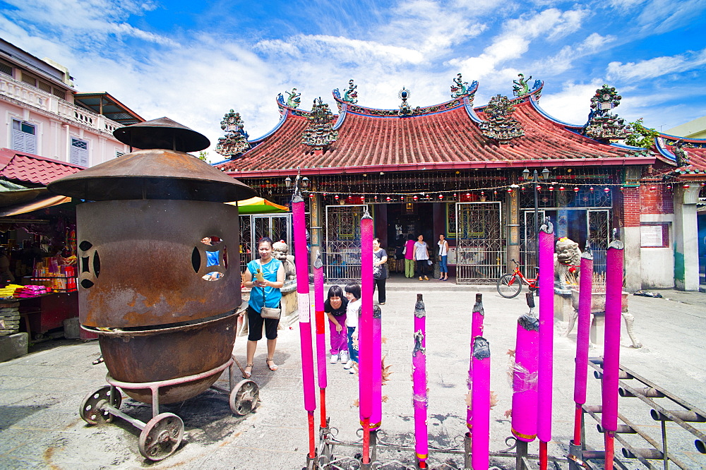 Malaysian people praying behind large incense sticks at a Buddhist temple in George Town, Penang, Malaysia, Southeast Asia, Asia