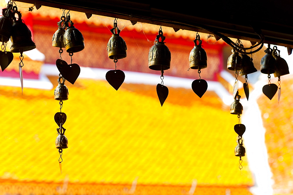 Close up of prayer bells, silhouetted against the colourful roof at Wat Doi Suthep, Chiang Mai, Thailand, Southeast Asia, Asia