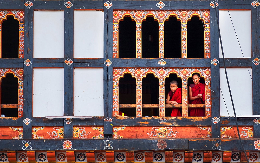 Bhutanese monks look through window frame, Kyichu Temple, Bhutan, Asia