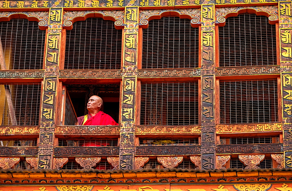 Portrait, mature Buddhist monk looking out of window, Punakha Dzong, Bhutan, Asia