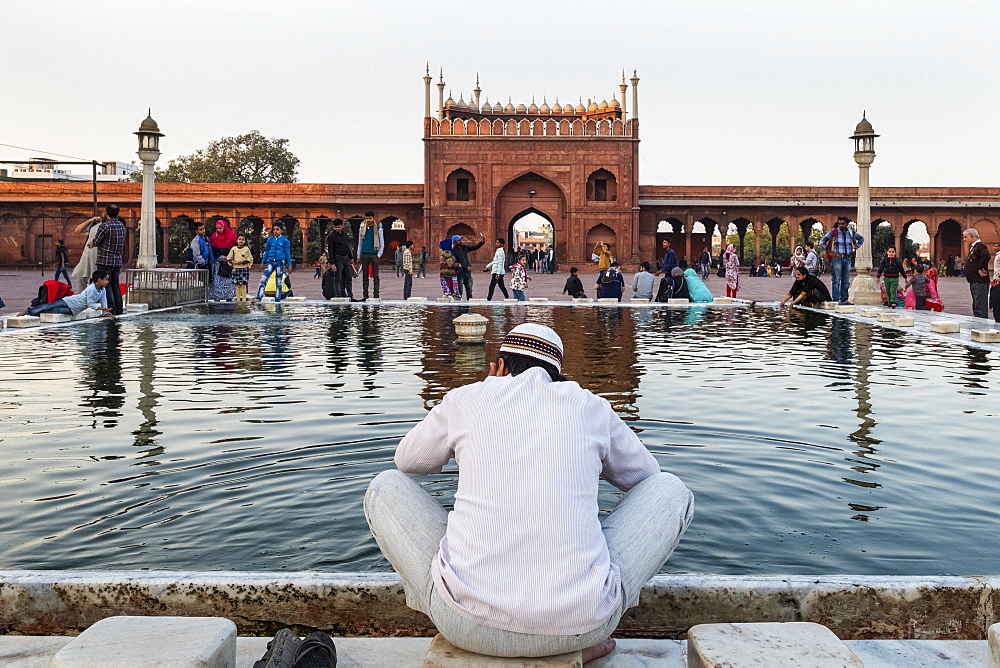 Muslim man washing hands and feet before prayer time, Jama Masjid, one of the largest mosques in India, South Asia