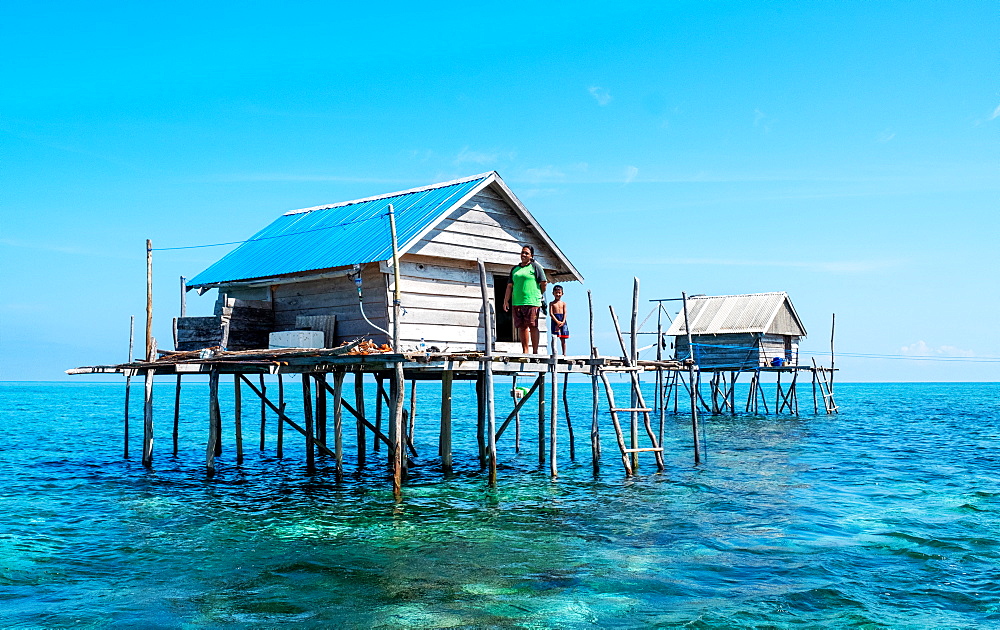 Women and young boy in hut built over the water by Bajau fishermen, who live there for three months, Togian Islands, Indonesia, Southeast Asia, Asia