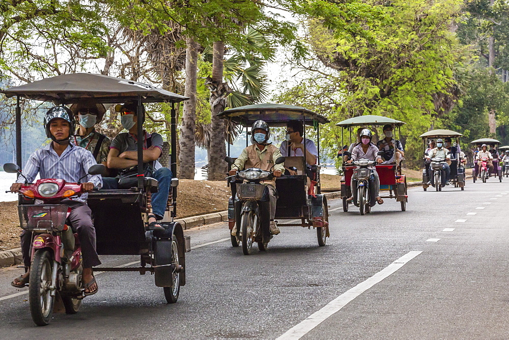 Tuk-tuks full of tourists on their way to Angkor Wat, Angkor, Siem Reap Province, Cambodia, Indochina, Southeast Asia, Asia