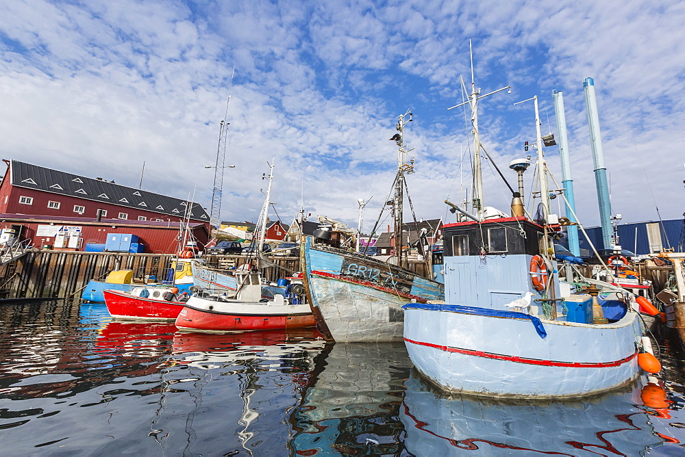 Commercial fishing and whaling boats line the busy inner harbor in the town of Ilulissat, Greenland, Polar Regions